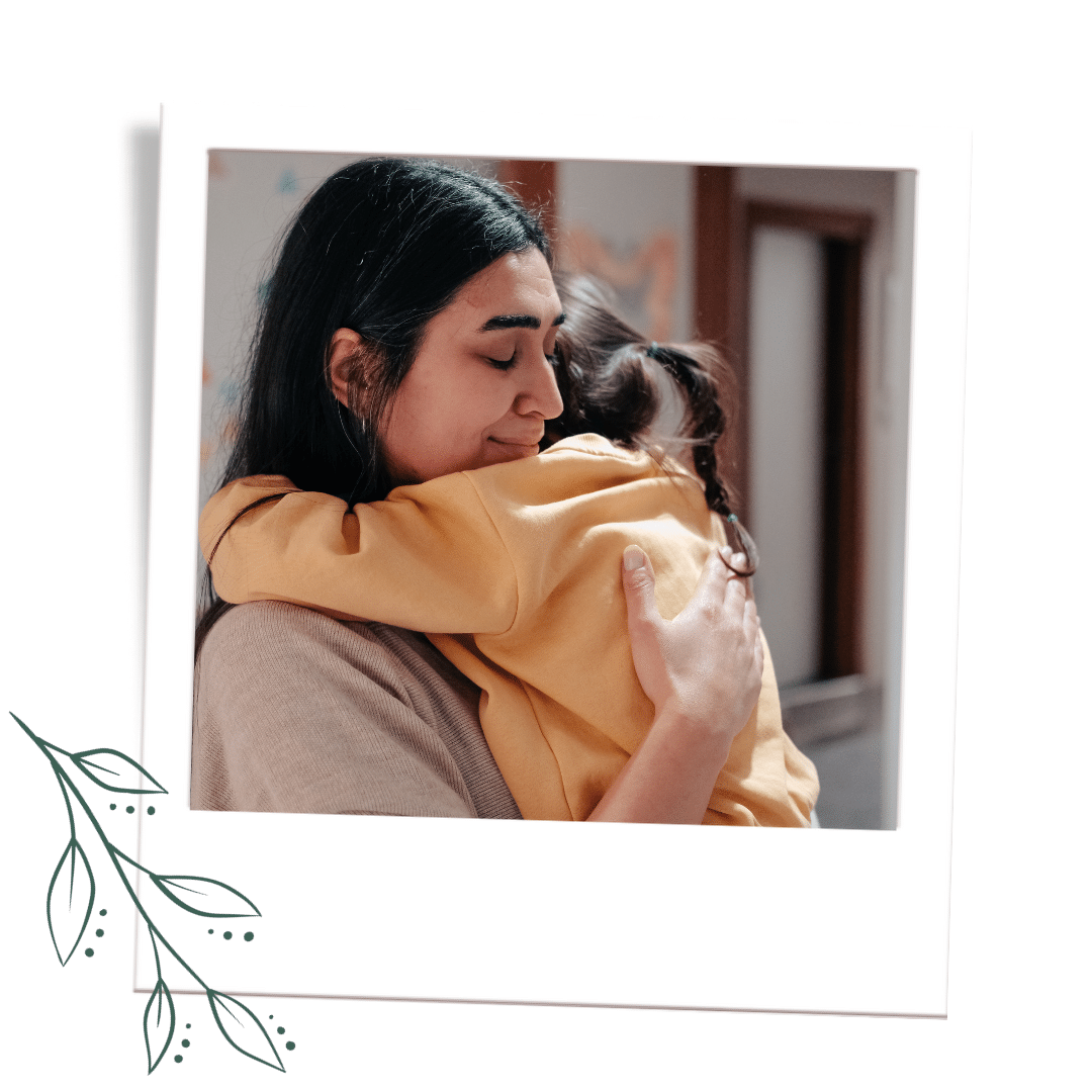 mother in beige shirt embraces young girl with yellow sweatshirt